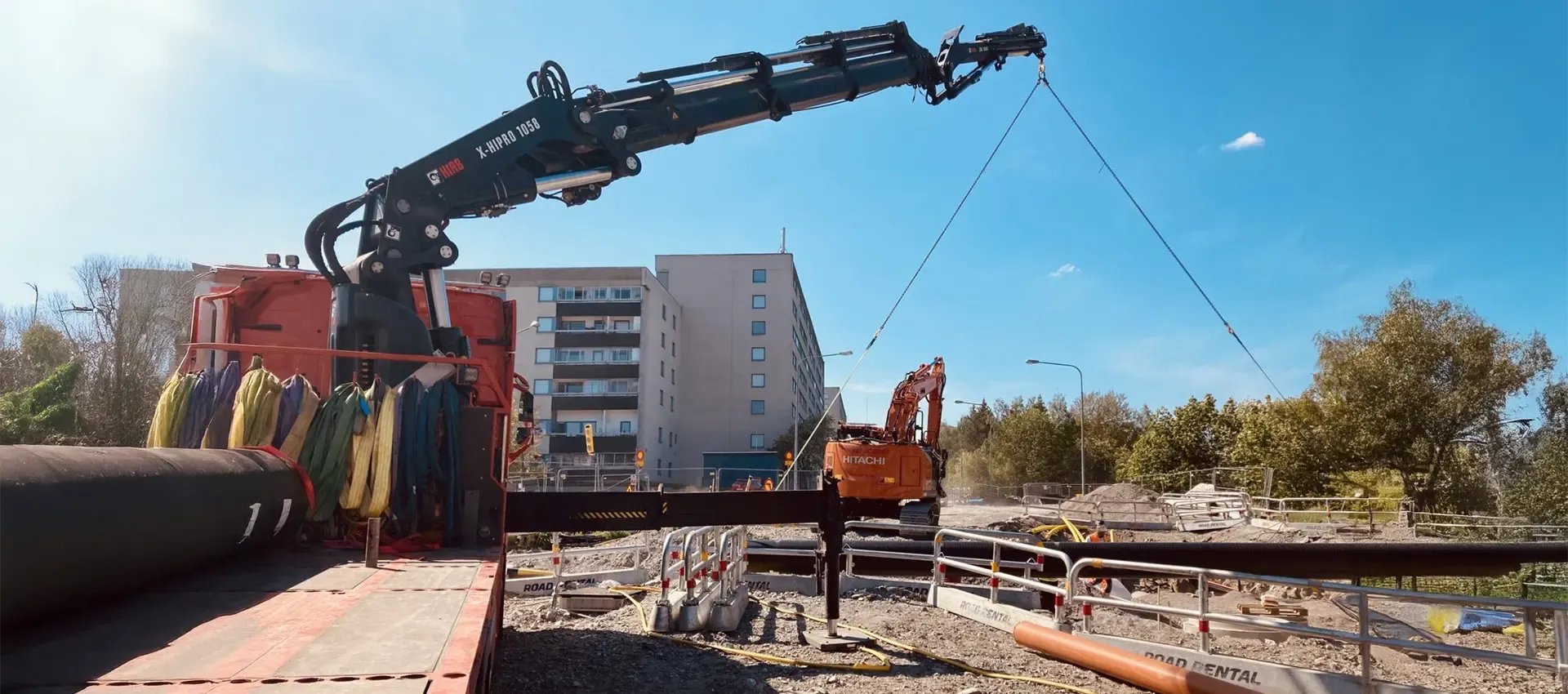 STC AB kranbil med rör på byggarbetsplats
